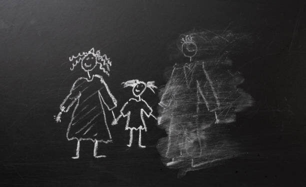 Chalk drawing of a child and parents on a blackboard, divorce trauma concept