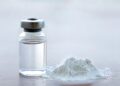 Vial of vaccine with drug powder on white background. GHB