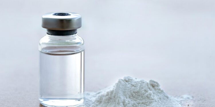 Vial of vaccine with drug powder on white background. GHB