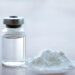 Vial of vaccine with drug powder on white background. GHB